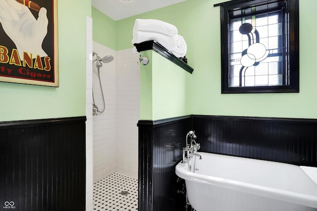 full bathroom with a stall shower, a soaking tub, and wainscoting