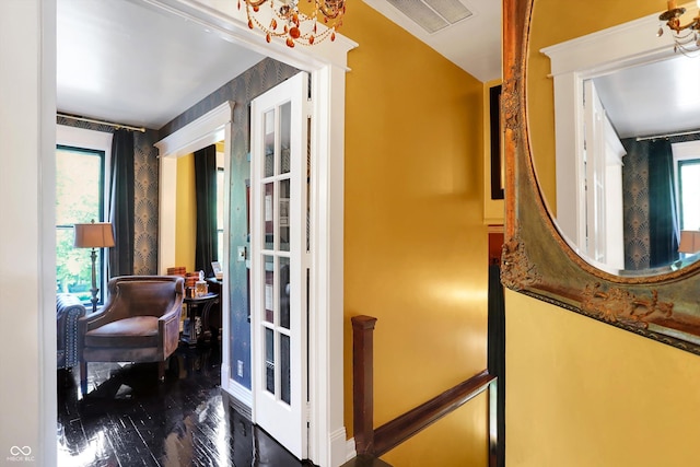 hallway featuring baseboards, visible vents, wood finished floors, and french doors