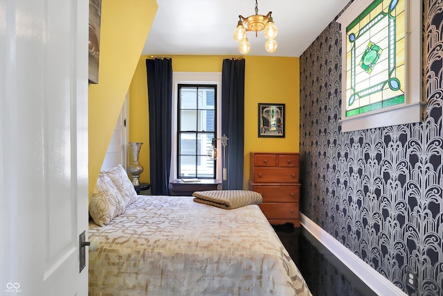 bedroom featuring a notable chandelier and baseboards