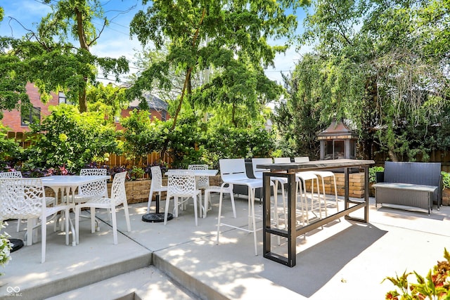 view of patio / terrace with an outdoor living space with a fireplace, fence, and outdoor dining area