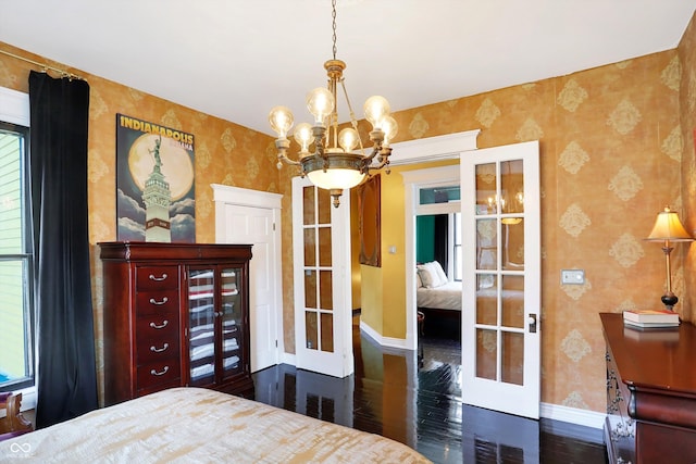 bedroom featuring wood finished floors, french doors, baseboards, and wallpapered walls