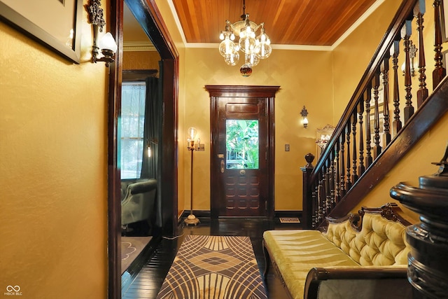 foyer entrance featuring wooden ceiling, stairway, ornamental molding, and a chandelier