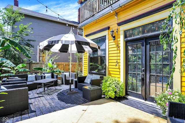 view of patio with fence, outdoor lounge area, and french doors