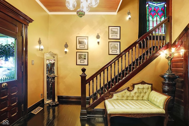 foyer featuring baseboards, stairs, ornamental molding, and wood finished floors