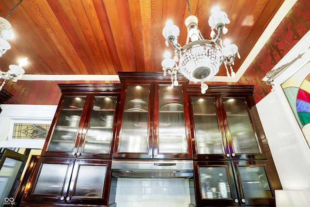 bar featuring wooden ceiling, under cabinet range hood, and a notable chandelier