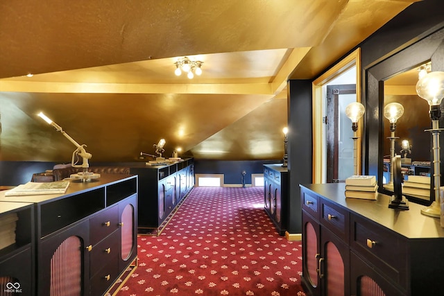 interior space featuring vaulted ceiling, baseboards, and dark colored carpet