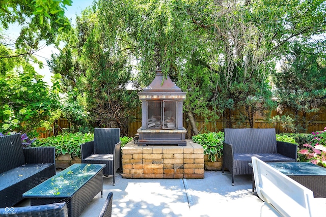 view of patio featuring fence and an outdoor living space with a fireplace