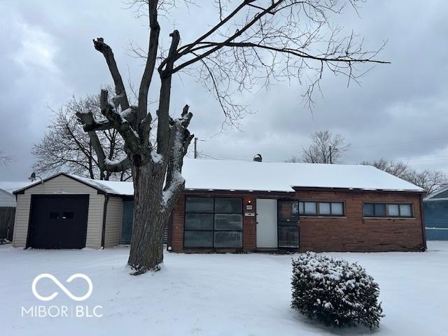 view of front of home with a garage and an outbuilding