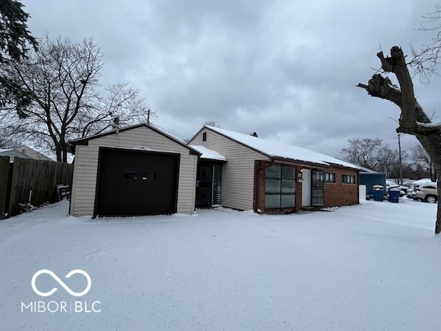 view of front of house featuring a garage, fence, and an outdoor structure