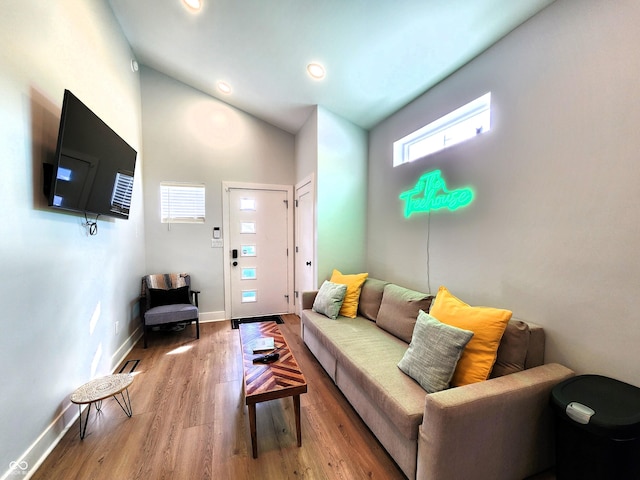 living room featuring lofted ceiling, recessed lighting, wood finished floors, and baseboards