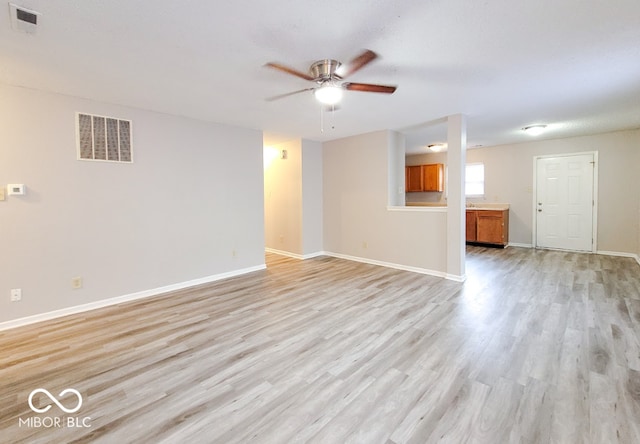 unfurnished living room featuring baseboards, a ceiling fan, visible vents, and light wood-style floors