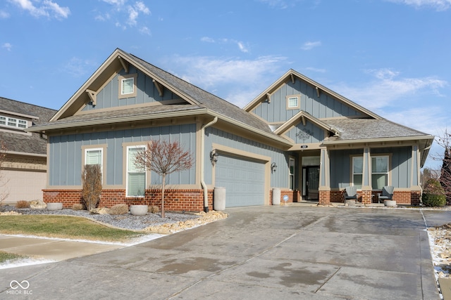 craftsman-style house with a garage, a shingled roof, concrete driveway, board and batten siding, and brick siding