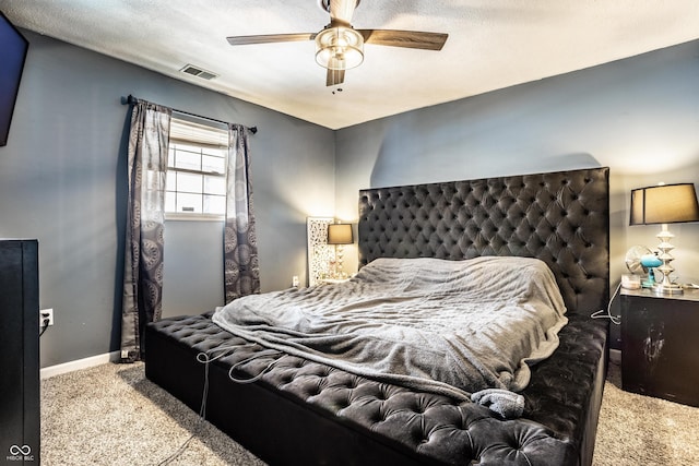 carpeted bedroom with a ceiling fan, visible vents, a textured ceiling, and baseboards