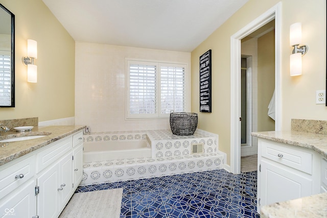 bathroom with tile patterned floors, two vanities, a sink, and a bath