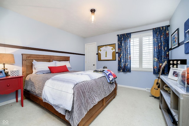 bedroom featuring light colored carpet and baseboards