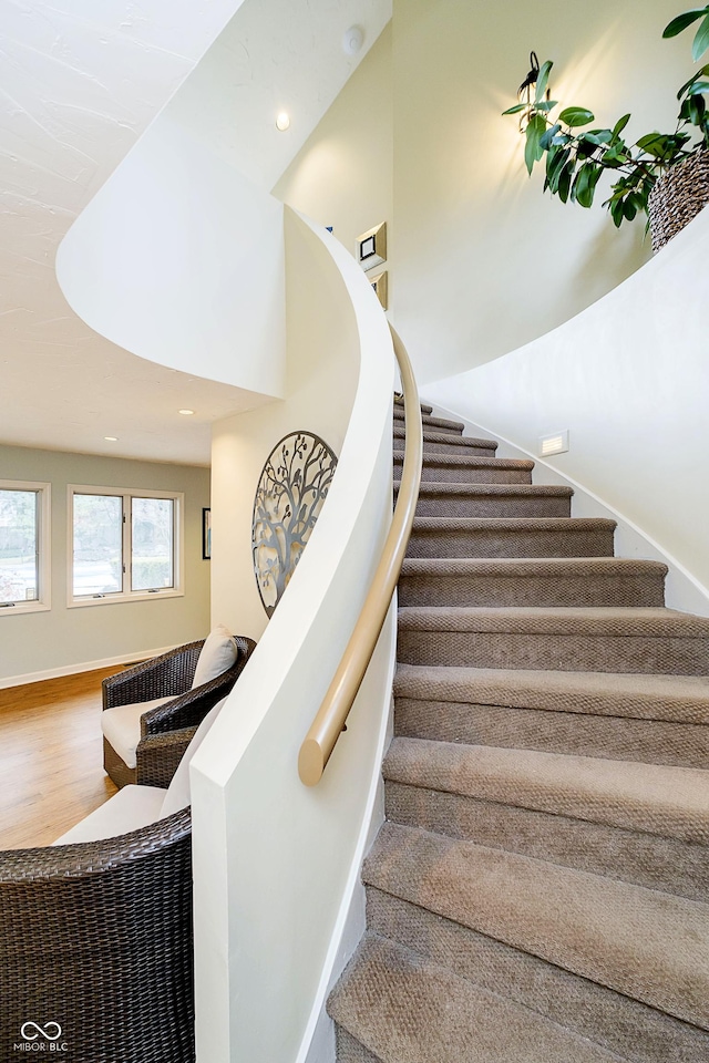 stairway featuring recessed lighting, baseboards, and wood finished floors