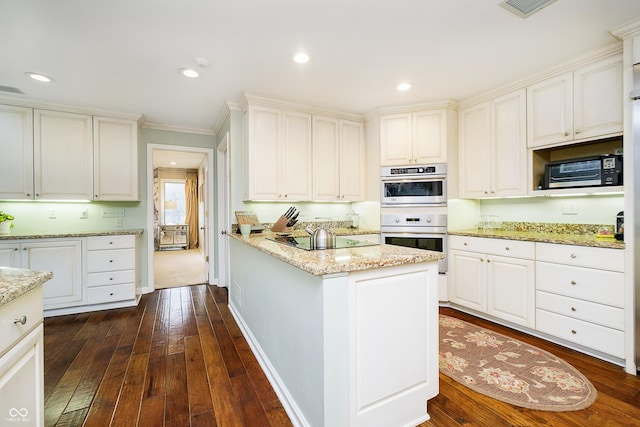 kitchen with light stone counters, a center island, dark wood-style floors, black electric stovetop, and double oven