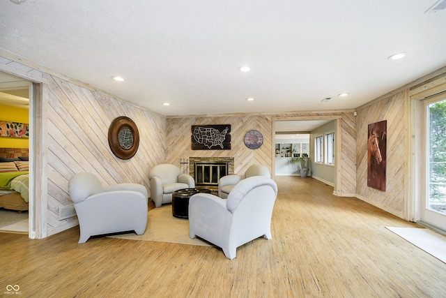 living room with light wood-type flooring, a brick fireplace, and recessed lighting