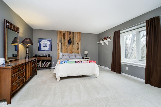 bedroom featuring light carpet and baseboards