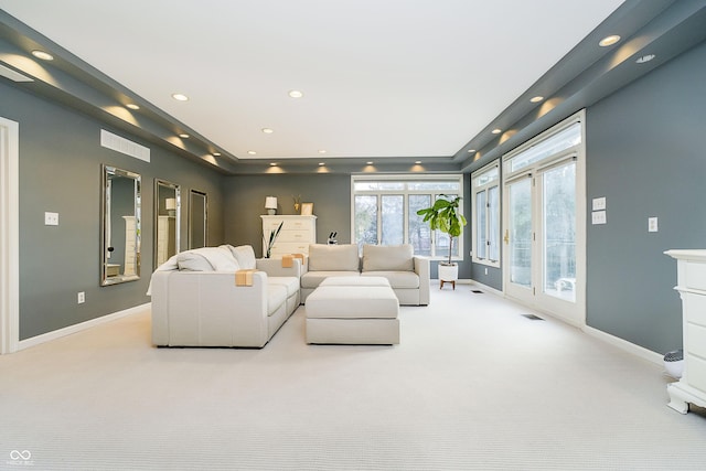 living room featuring recessed lighting, light carpet, visible vents, and baseboards