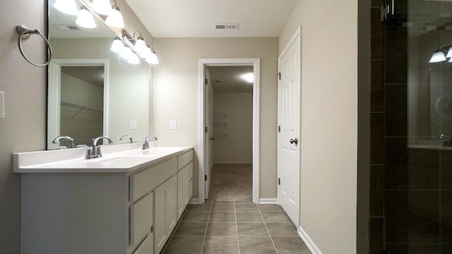 full bathroom with visible vents, double vanity, a tile shower, a sink, and tile patterned floors