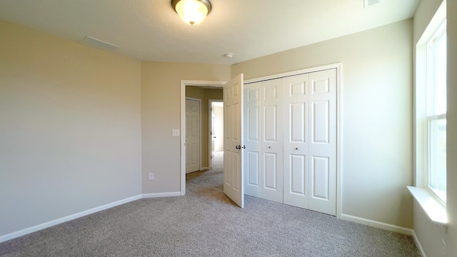 unfurnished bedroom with carpet, baseboards, and a closet