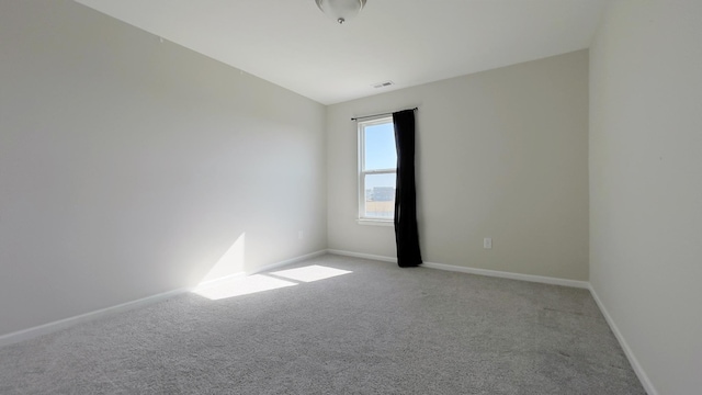 carpeted empty room featuring visible vents and baseboards