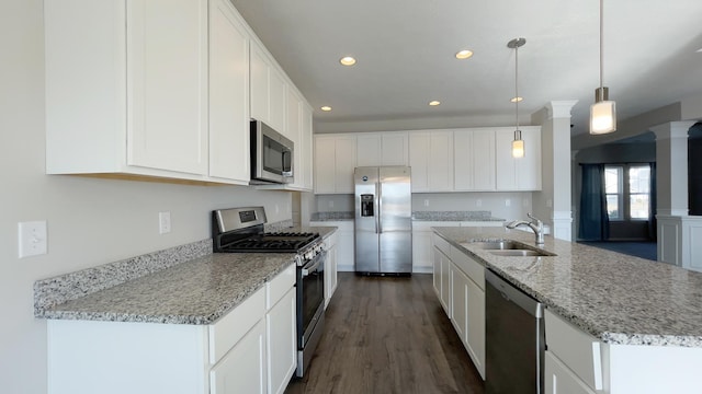 kitchen with dark wood-style floors, white cabinets, stainless steel appliances, and a sink