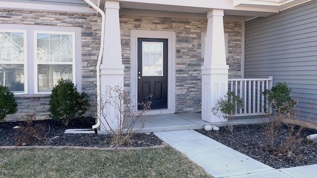 entrance to property featuring covered porch and stone siding