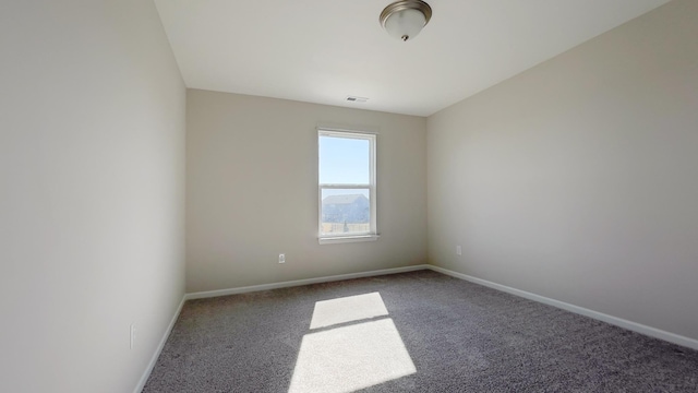 carpeted spare room with visible vents and baseboards