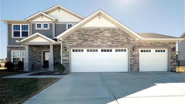 craftsman house with an attached garage and stone siding