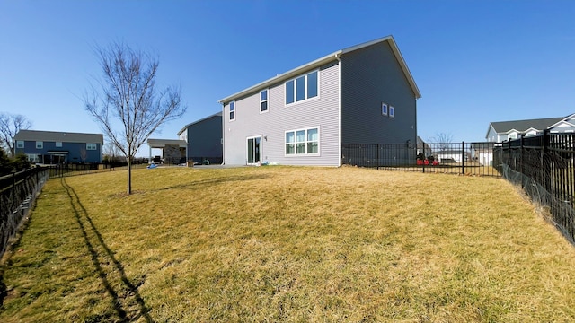 back of property with a lawn and a fenced backyard