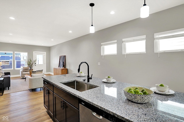 kitchen featuring plenty of natural light, pendant lighting, a sink, and light wood finished floors