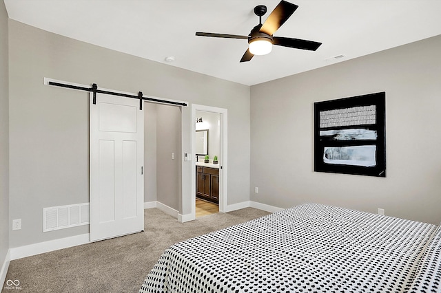 bedroom featuring baseboards, a barn door, visible vents, and light colored carpet