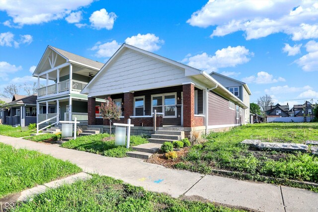 1624 Prospect St, Indianapolis, IN 46203 - bungalow-style home featuring a porch, a residential view, a balcony, and brick siding