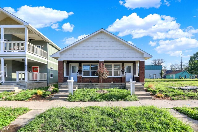 1624 Prospect St, Indianapolis, IN 46203 - view of front of home with a porch, a balcony, and brick siding
