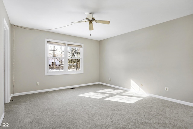 spare room with baseboards, a ceiling fan, and light colored carpet