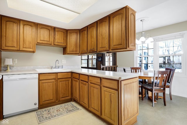 kitchen featuring dishwasher, light countertops, a peninsula, and pendant lighting