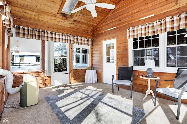 sunroom with a ceiling fan, vaulted ceiling with skylight, and wood ceiling