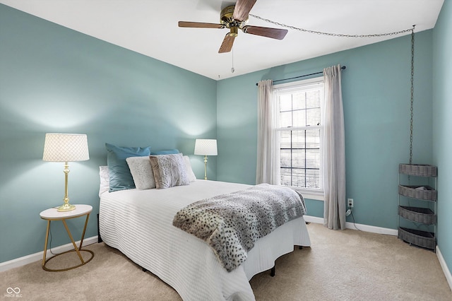 bedroom with ceiling fan, light colored carpet, and baseboards