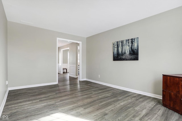 unfurnished room featuring baseboards and wood finished floors