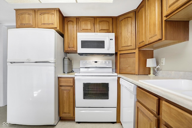 kitchen featuring light countertops, white appliances, and brown cabinetry