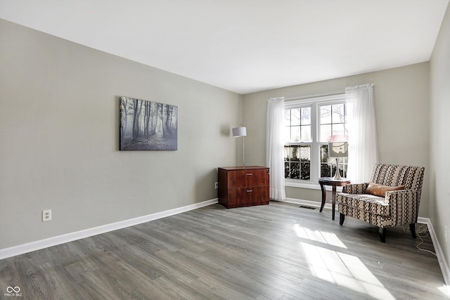 living area with light wood-style flooring and baseboards