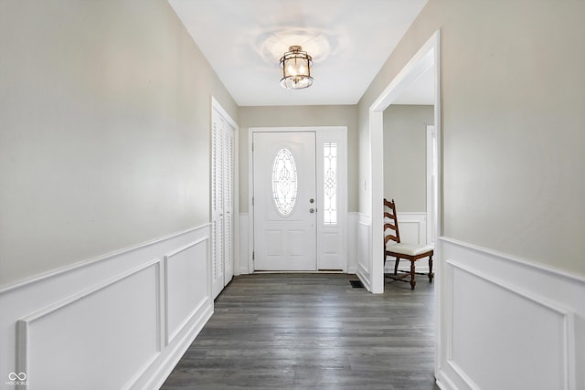 entryway with dark wood-style flooring and wainscoting