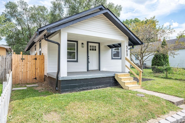 view of front of property with a porch, fence, and a front lawn