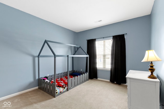 bedroom featuring baseboards, visible vents, and light colored carpet