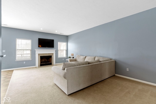 living room with a fireplace with flush hearth, recessed lighting, light colored carpet, and baseboards