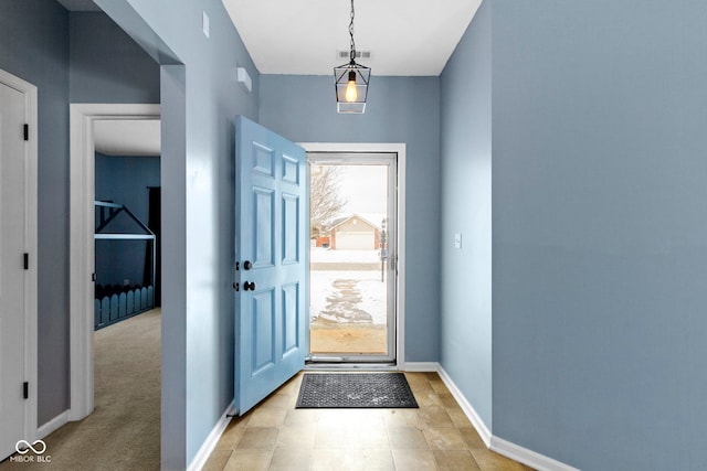 doorway to outside with light carpet, visible vents, and baseboards