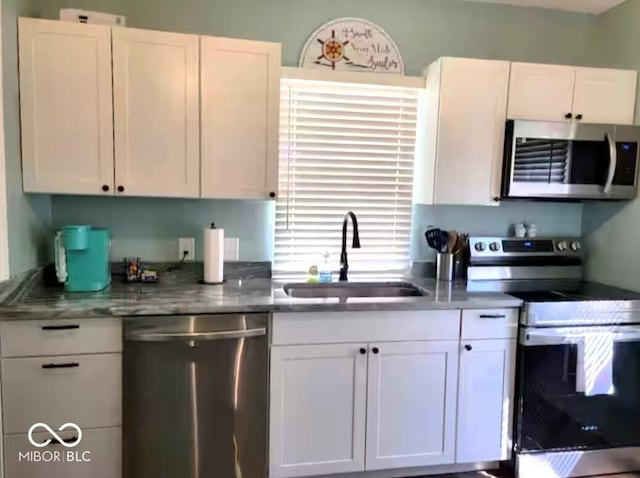 1046 Nelson Ave, Indianapolis, IN 46203 - kitchen featuring white cabinets, a sink, and appliances with stainless steel finishes