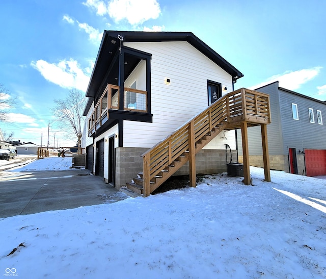 snow covered property featuring stairs and a deck